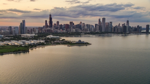 AX0003_029.0000000F - Aerial stock photo of Downtown Chicago skyline and the Adler Planetarium seen from Lake Michigan, at sunset, Illinois