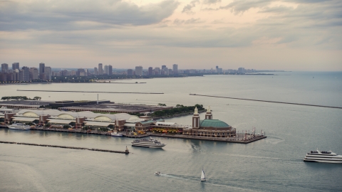 AX0003_063.0000418F - Aerial stock photo of Two ferries by the end of the Navy Pier on a cloudy day at sunset, Chicago, Illinois