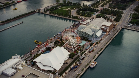 AX0003_068.0000069F - Aerial stock photo of Ferris wheel and amusement park rides on Navy Pier at sunset, Chicago, Illinois