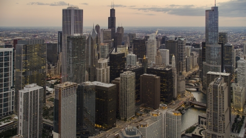 AX0003_079.0000288F - Aerial stock photo of Skyscrapers and high-rises by Chicago River at twilight in Downtown Chicago, Illinois