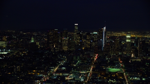 AX0158_085.0000268 - Aerial stock photo of Towering skyscrapers of the city's skyline at night in Downtown Los Angeles, California