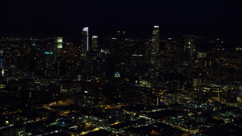 AX0158_093.0000359 - Aerial stock photo of The city skyline's tall skyscrapers at night in Downtown Los Angeles, California