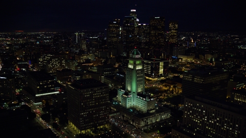 AX0158_103.0000016 - Aerial stock photo of City Hall and the city's skyscrapers at night in Downtown Los Angeles, California