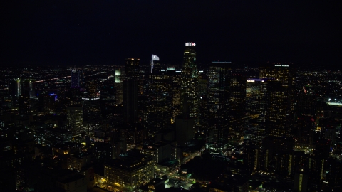 AX0158_110.0000136 - Aerial stock photo of Tall city skyscrapers at night in Downtown Los Angeles, California