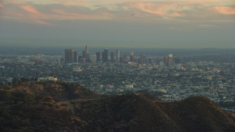 The skyline of Downtown Los Angeles, California at twilight and Griffith Observatory Aerial Stock Photos | AX0162_105.0000154