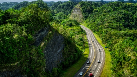 Light highway  traffic through lush green mountains, Karst Forest, Puerto Rico  Aerial Stock Photos | AX101_078.0000299F