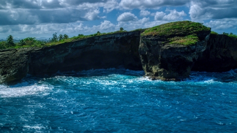 AX101_162.0000151F - Aerial stock photo of Rugged rock formation on the Caribbean island coast in Arecibo, Puerto Rico 