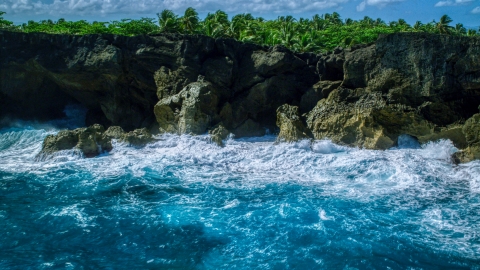 AX101_163.0000000F - Aerial stock photo of Coastal rock formations and caves, and crashing ocean waves in Arecibo, Puerto Rico 