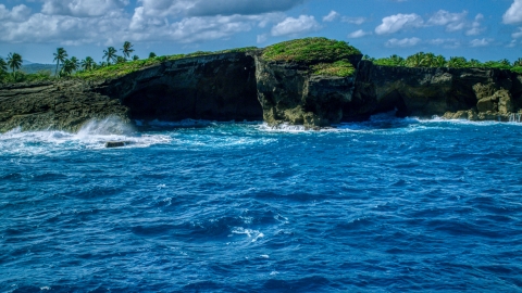 AX101_165.0000040F - Aerial stock photo of Rock formations on the rugged island coast and crystal blue water, Arecibo, Puerto Rico 