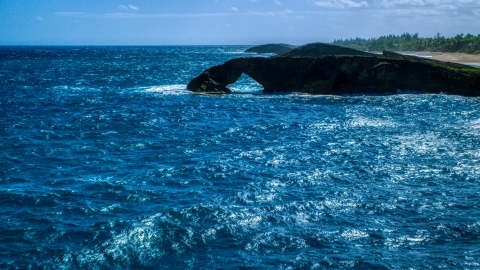 An arched rock formation in crystal blue water, Arecibo, Puerto Rico Aerial Stock Photos | AX101_168.0000129F