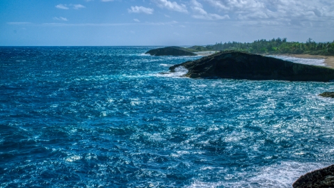 AX101_169.0000312F - Aerial stock photo of Domed rock formation in crystal blue waters, Arecibo, Puerto Rico