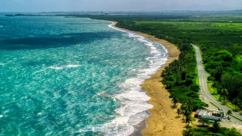 AX101_221.0000226F - Aerial stock photo of Beach and highway beside crystal blue waters, Dorado, Puerto Rico