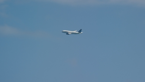 A passenger plane in blue skies over Carolina, Puerto Rico Aerial Stock Photos | AX102_014.0000032F