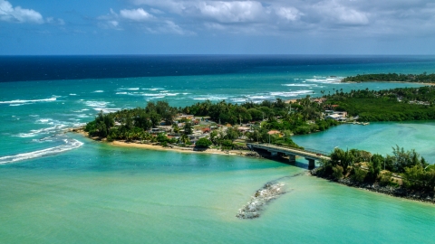 AX102_015.0000000F - Aerial stock photo of Small island shops beside a small bridge in Loiza, Puerto Rico