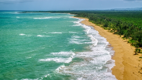 Waves rolling in to an empty Caribbean island beach in Loiza, Puerto Rico  Aerial Stock Photos | AX102_022.0000119F