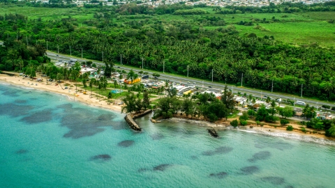 AX102_048.0000000F - Aerial stock photo of Highway and beachfront shops and restaurants in Luquillo, Puerto Rico 