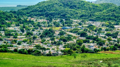 Homes beside tree covered hills, Fajardo, Puerto Rico  Aerial Stock Photos | AX102_055.0000000F