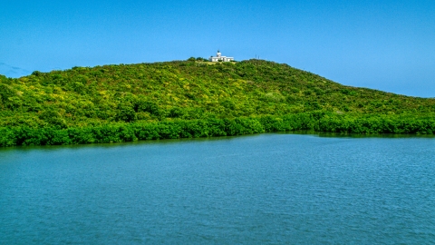 AX102_061.0000230F - Aerial stock photo of Cape San Juan Light on a hilltop in Fajardo, Puerto Rico 