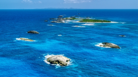 Tiny green Caribbean island in tropical blue waters, and smaller rocky islands, Puerto Rico  Aerial Stock Photos | AX102_088.0000024F