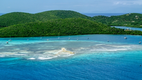 AX102_140.0000000F - Aerial stock photo of Sailboats in turquoise waters beside a tree covered island coast, Culebra, Puerto Rico 