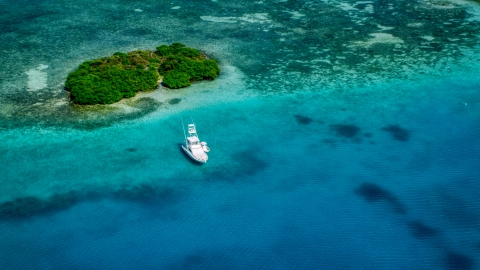 AX102_172.0000132F - Aerial stock photo of Fishing boat anchored near a reef and tiny Caribbean island, Culebra, Puerto Rico