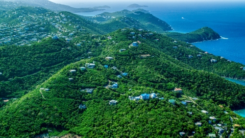 AX102_259.0000000F - Aerial stock photo of Hilltop island homes over looking the blue ocean waters by the coast, East End, St Thomas 