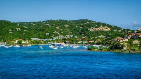 AX103_029.0000072F - Aerial stock photo of Blue Caribbean waters in the harbor near hillside homes, Cruz Bay, St John