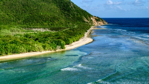 AX103_046.0000037F - Aerial stock photo of A Caribbean beach along jungle and sapphire blue Caribbean waters, Reef Bay, St John