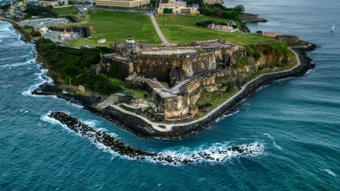 A view of Fort San Felipe del Morro along Caribbean blue waters, Old San Juan, twilight Aerial Stock Photos | AX104_084.0000000F