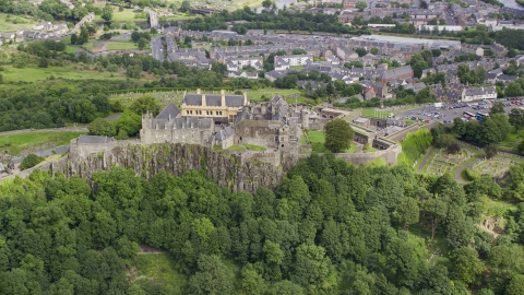 Stirling Castle atop a hill covered with trees, Scotland Aerial Stock Photos | AX109_038.0000000F