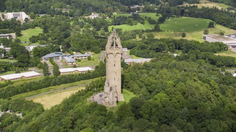 AX109_049.0000000F - Aerial stock photo of The historic Wallace Monument on a tree-covered hill, Stirling, Scotland