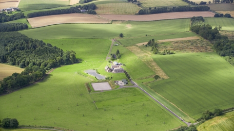 A sheep farm and green fields in Stirling, Scotland Aerial Stock Photos | AX109_061.0000000F