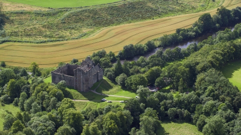 Historic Doune Castle beside a river in Scotland Aerial Stock Photos | AX109_066.0000137F