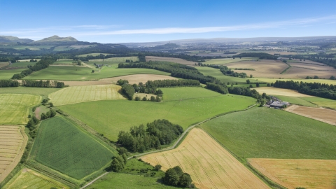 AX109_089.0000000F - Aerial stock photo of Farm and fields along a country road, Doune, Scotland