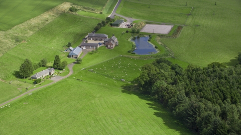 AX109_091.0000000F - Aerial stock photo of A sheep farm and pond, Stirling, Scotland