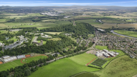 The Wallace Monument on a hill near a residential area, Stirling, Scotland Aerial Stock Photos | AX109_097.0000160F