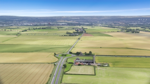 AX109_115.0000040F - Aerial stock photo of A roundabout on A905 highway by farm fields, Falkirk, Scotland