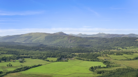 AX110_040.0000000F - Aerial stock photo of Scottish forest, farmland and mountains, Aberfoyle, Scotland