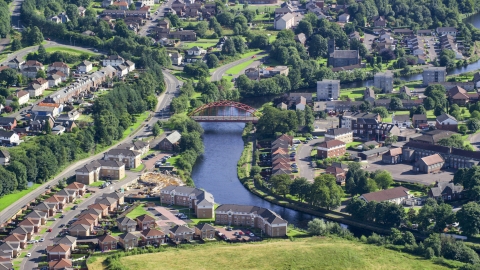 AX110_133.0000150F - Aerial stock photo of Small bridge on River Leven through residential neighborhood, Alexandria, Scotland