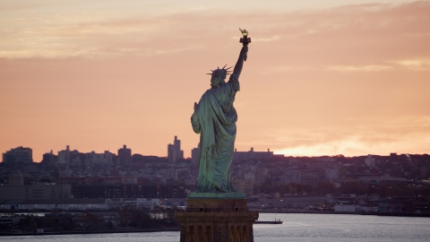 AX118_042.0000079F - Aerial stock photo of Back of the Statue of Liberty at sunrise, New York