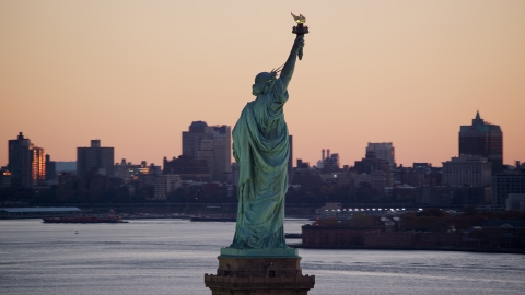 Statue of Liberty, and Brooklyn across the harbor at sunrise, New York Aerial Stock Photos | AX118_044.0000000F