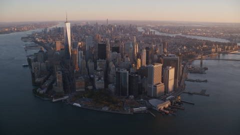 AX118_086.0000165F - Aerial stock photo of Battery Park and Lower Manhattan skyscrapers at sunrise, New York City