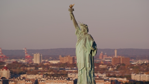 AX118_104.0000067F - Aerial stock photo of The front side of the Statue of Liberty at sunrise in New York