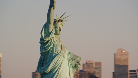 AX118_108.0000070F - Aerial stock photo of Profile of the Statue of Liberty at sunrise in New York