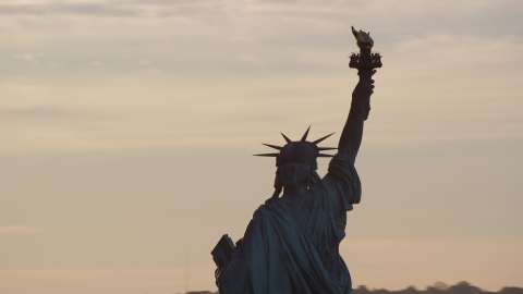 AX118_111.0000148F - Aerial stock photo of The back of the Statue of Liberty at sunrise in New York