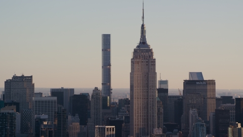 AX118_166.0000205F - Aerial stock photo of Empire State Building and 432 Park Avenue at sunrise in Midtown Manhattan, New York City