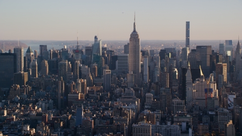 AX118_168.0000173F - Aerial stock photo of Empire State Building and Midtown skyscrapers at sunrise in New York City