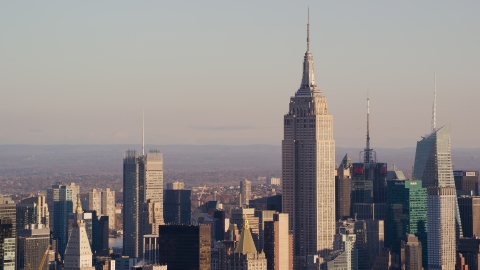 AX118_174.0000088F - Aerial stock photo of The Empire State Building in Midtown Manhattan at sunrise in New York City