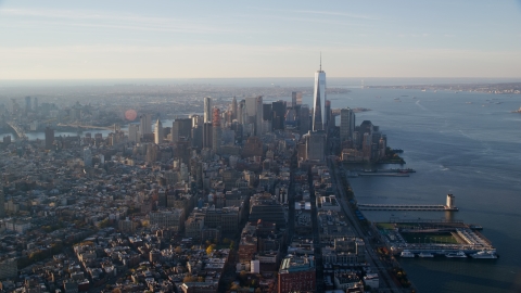 AX118_208.0000101F - Aerial stock photo of Lower Manhattan and piers on the Hudson at sunrise in New York City