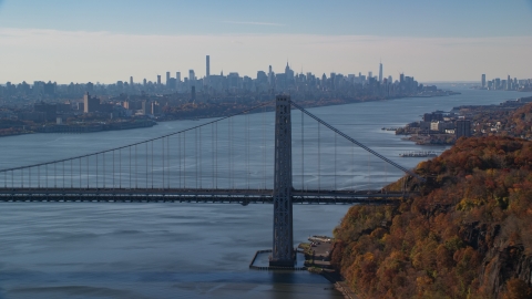 AX119_050.0000022F - Aerial stock photo of Midtown skyline behind the George Washington Bridge and the Hudson River in Autumn, New York City